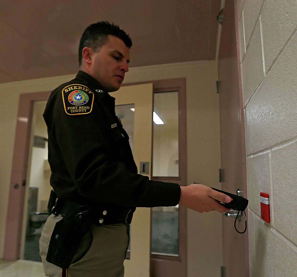 Fort Bend County Sheriff Deputy A. Smith scans an RFID location point during a demonstration of the GUARDIAN RFID inmate management system Thursday, Jan. 21, 2016, in Richmond. Fort Bend County jail is implementing a new electronic system for guards making their rounds.
