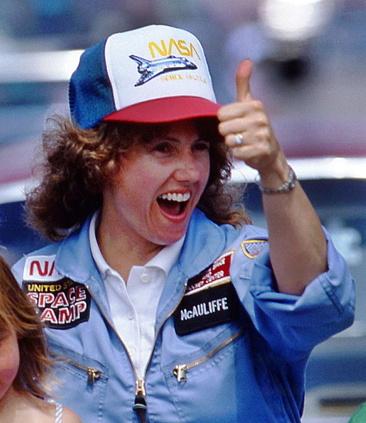 In this 1985 photo, high school teacher Christa McAuliffe gives a thumbs-up during a parade down Main Street in Concord, N.H. McAuliffe was one of seven crew members killed in the Space Shuttle Challenger explosion on Jan. 28, 1986. (AP Photo/Jim Cole)