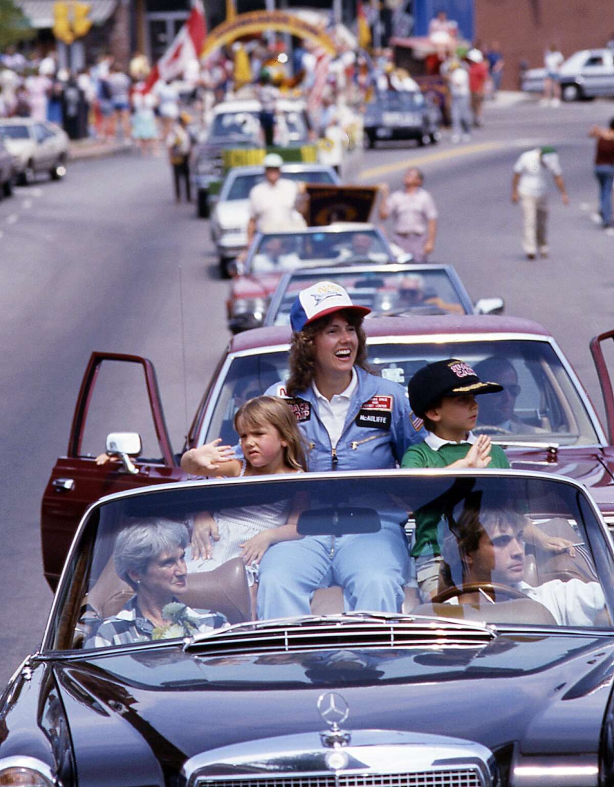 In this 1985 photo, high school teacher Christa McAuliffe rides with her children Caroline, left, and Scott during a parade down Main Street in Concord, N.H. McAuliffe was one of seven crew members killed in the Space Shuttle Challenger explosion on Jan. 28, 1986. (AP Photo/Jim Cole)