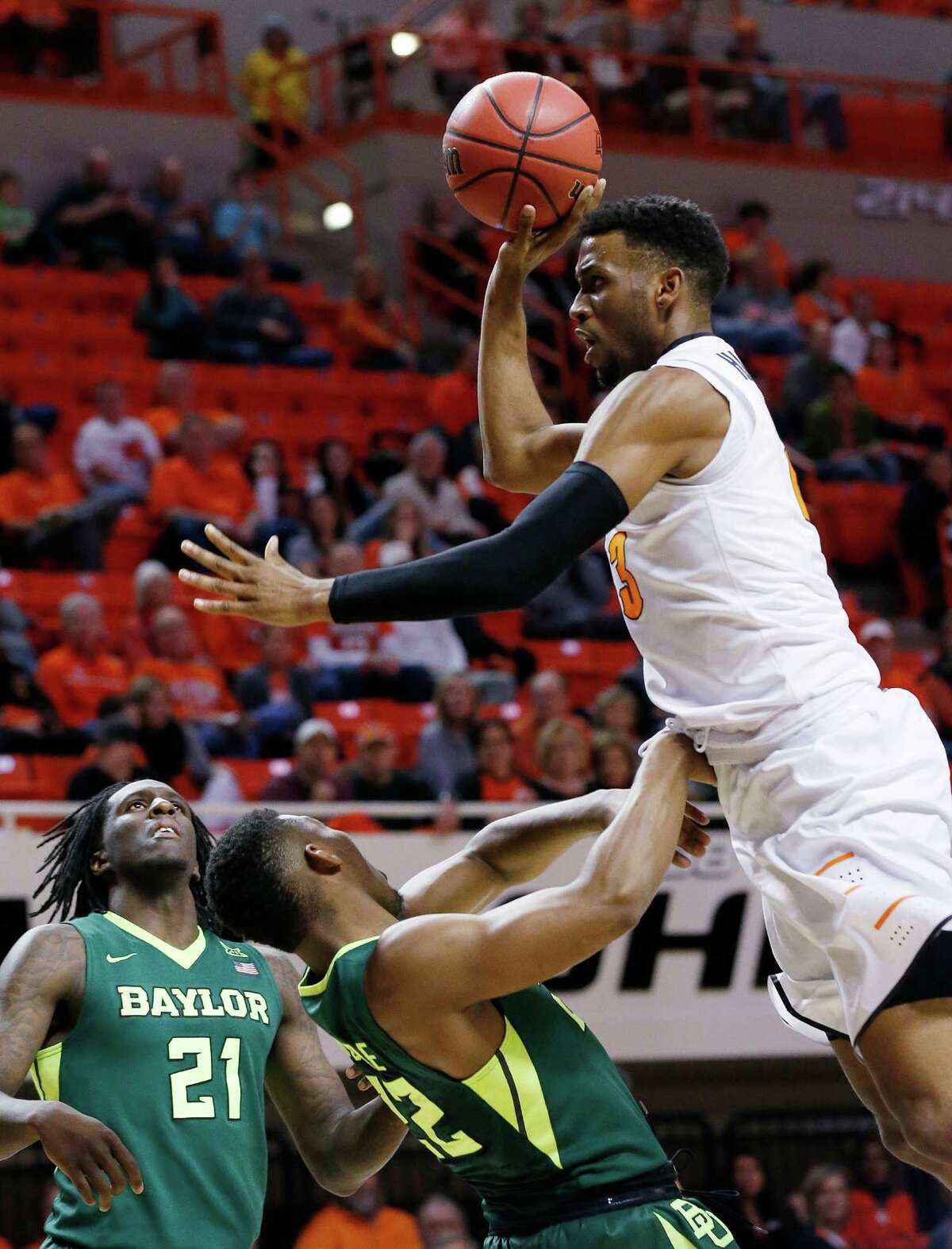 Oklahoma State guard Leyton Hammonds, right, is fouled by Baylor guard King McClure, center, as he shoots during the first half of an NCAA college basketball game in Stillwater, Okla., Wednesday, Jan. 27, 2016. Baylor forward Taurean Prince is at left. (AP Photo/Sue Ogrocki)