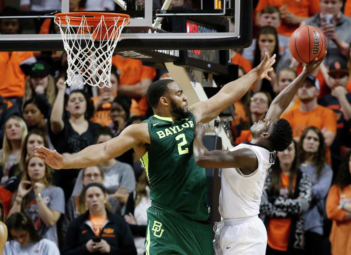 Baylor's Rico Gathers, left, adds to the degree of difficulty on Jawun Evans' shot.