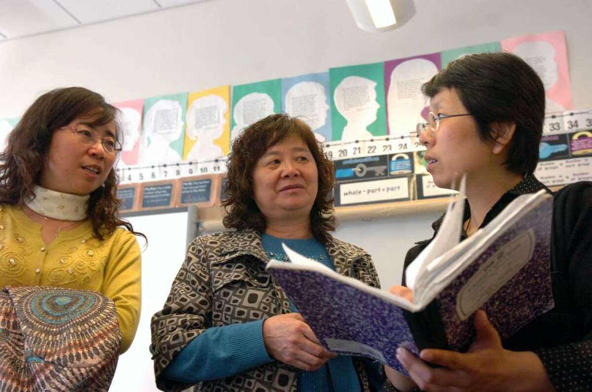 Faculty members from China's Fu Xiao Primary School from left, assistant principal Shu Juan, Chinese teacher Zhang Xi Fang and English teacher Kelly Zhang discuss the journal of a Greenwich student at Hamilton Avenue School Monday morning April 5, 2010. For the past week students and faculty from Parkway's sister school Fu Xiao Primary School in China's Xi'an Province have been visiting Greenwich in a cross-cultural exchange program, an extension of Parkway's China Connection Program, which branches out to other schools in Greenwich.