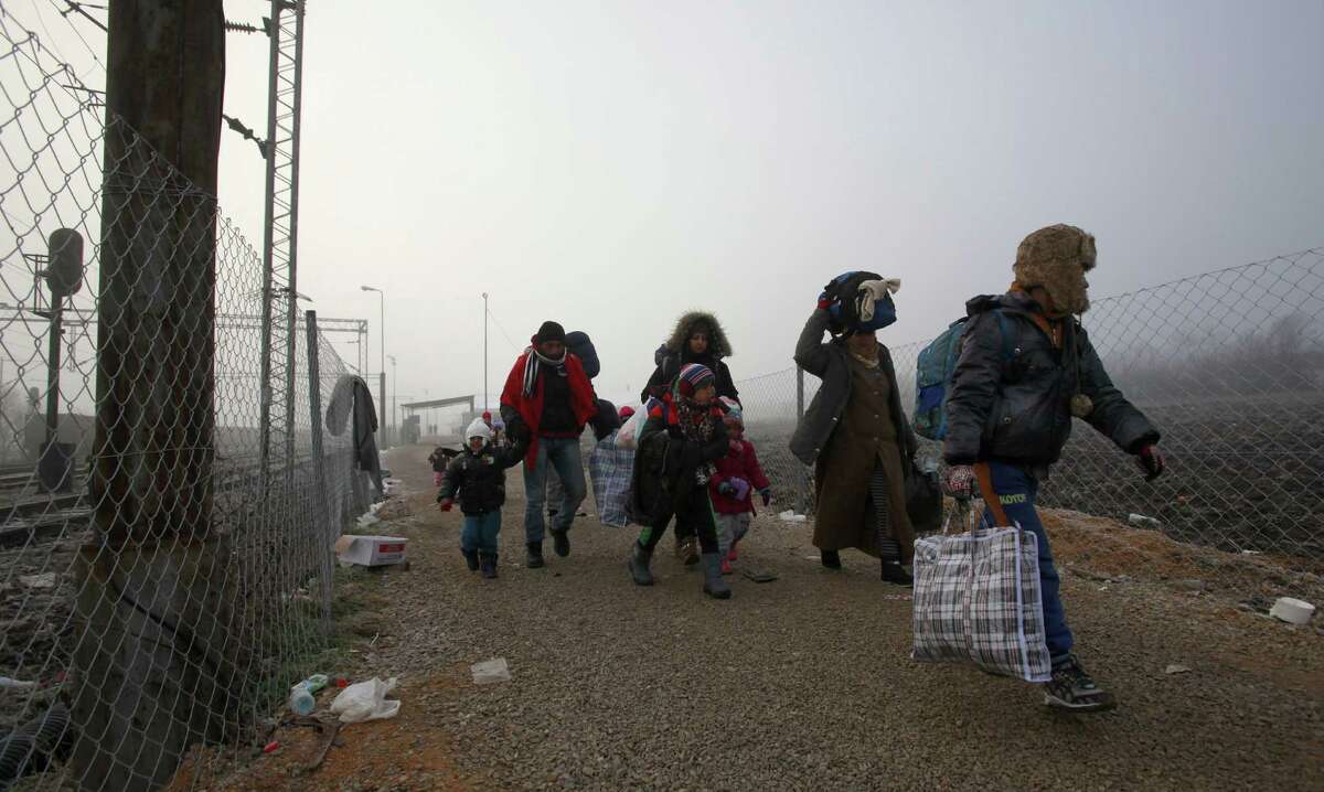 Refugees walk towards the border with Serbia from the transit center for refugees near northern Macedonian village of Tabanovce, Thursday, Jan. 28, 2016. Macedonia allows in migrants whom it deems to be bona fide refugees - Syrian, Iraqi and Afghan nationals. All others are considered economic migrants and left trapped in Greece, where they are told to seek asylum, agree to voluntary repatriation or be deported. (AP Photo/Boris Grdanoski)