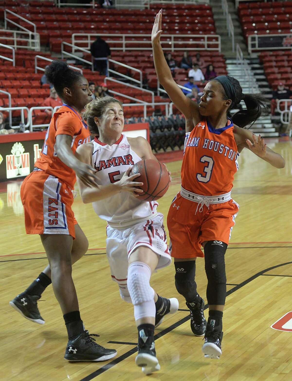 Lamar's Baileigh O'Dell battles through the blocking efforts of Sam Houston State's Jasmine McCants (left) and Shernise Robertson as she drives toward the basket during Wednesday night's match-up at the Montagne Center. Photo taken Wednesday, January 27, 2016 Kim Brent/The Enterprise
