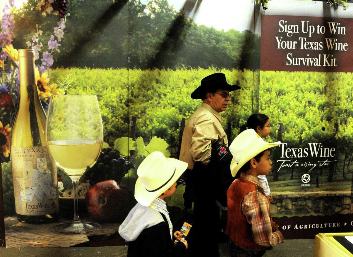 Raul Fernandez walks with his children (from left) Alexander, Sebastian and Vicki in the Texas Wine exhibit at the San Antonio Stock Show & Rodeo Feb. 12, 2011.