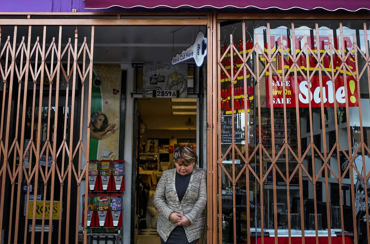 Araceli Espinoza, co-owner of Thalia's Jewelry looks down as she poses for a portrait at the entrance of her store, in San Francisco, California on Thursday, January 28, 2016. Espinoza said it was an emotional day for her, as January 28th marks the one-year anniversary of the fire that destroyed their previous jewelry store.