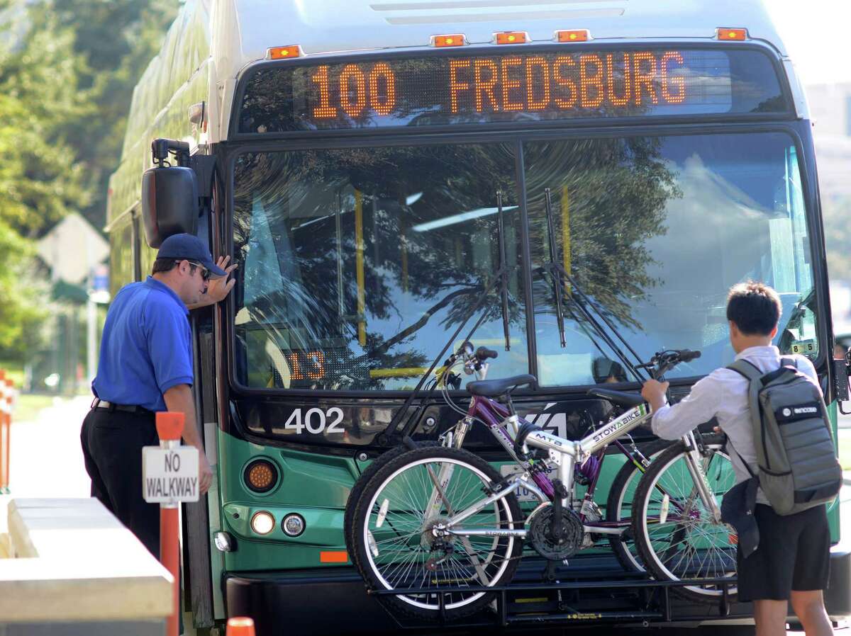 A man places his bicycle on a VIA Primo rapid transit bus along Medical Drive in October. With public outreach and educational materials, VIA is reminding passengers of basic road safety practices: Use crosswalks, look before crossing and don’t chase the bus or attempt to stop it.