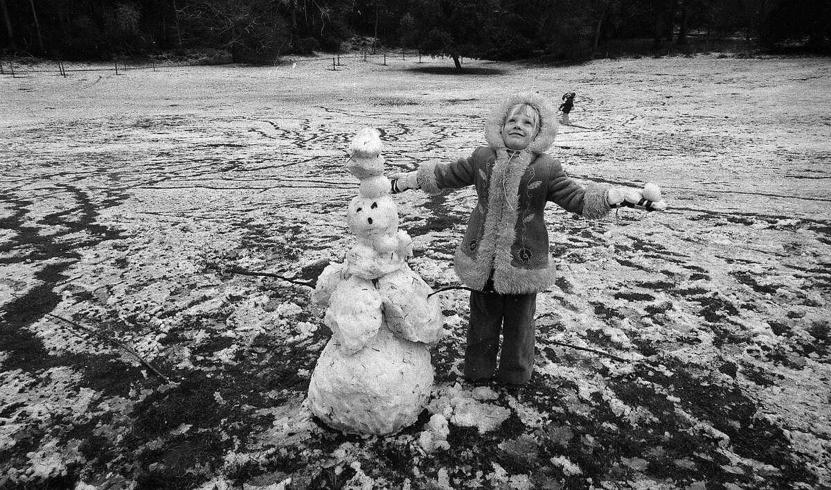 On Feb. 5, 1976, a girl builds a snowman in Golden Gate Park during a rare San Francisco snowfall.