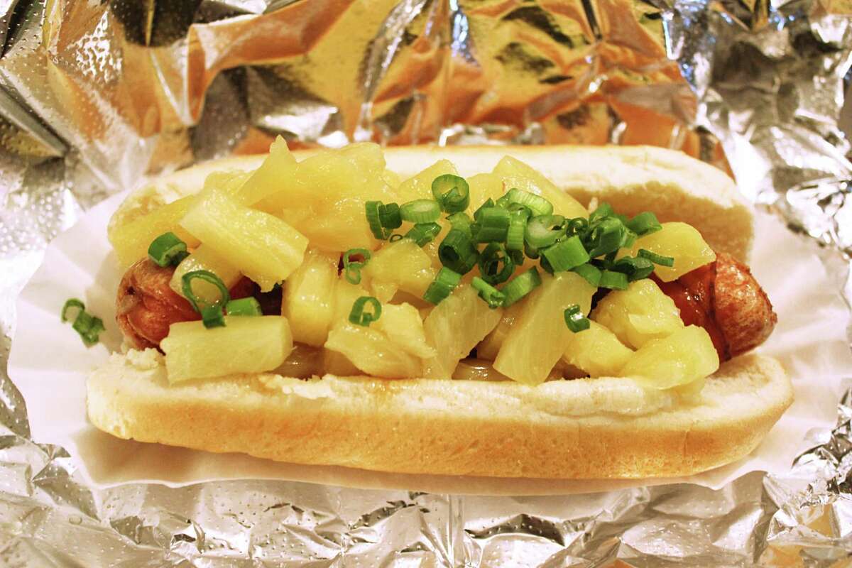 At Crif Dogs, hot dogs are deep-fried and come in a multitude of styles, like this bacon-wrapped dog with teriyaki sauce, pineapple and green onions. The eatery is featured in “New York’s One-Food Wonders.”
