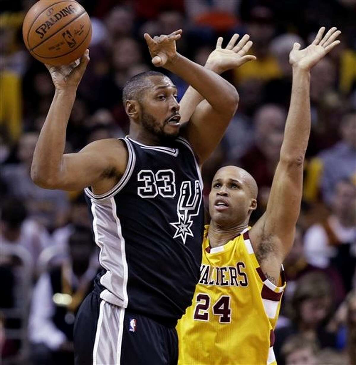 San Antonio Spurs' Boris Diaw (33) passes in front of Cleveland Cavaliers' Richard Jefferson (24) during the first half of an NBA basketball game Saturday, Jan. 30, 2016, in Cleveland. (AP Photo/Tony Dejak)
