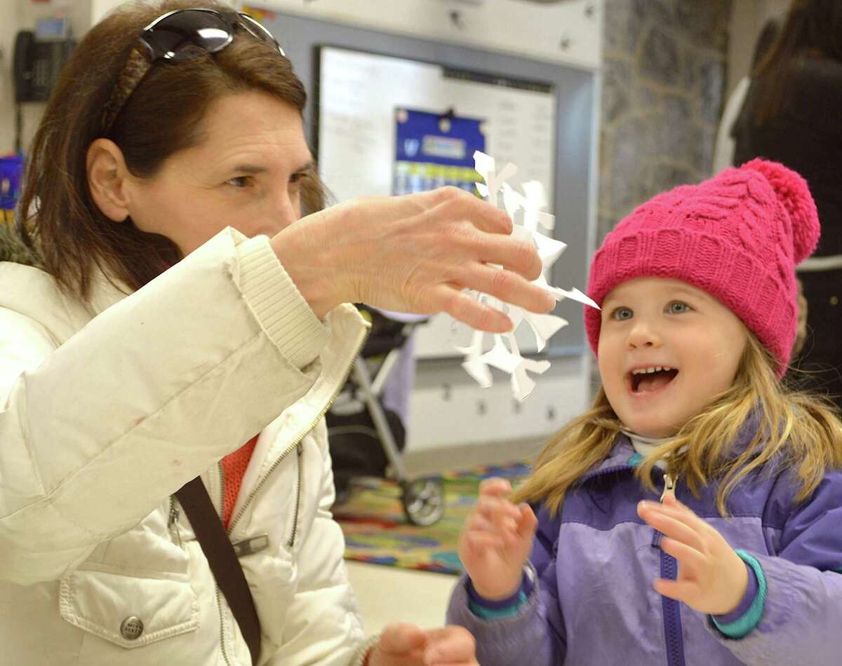 Peyton Dunbar, 3, of Weston, was starry-eyed by the snowflake her mother, Staci, cut out of paper during Winterfest.
