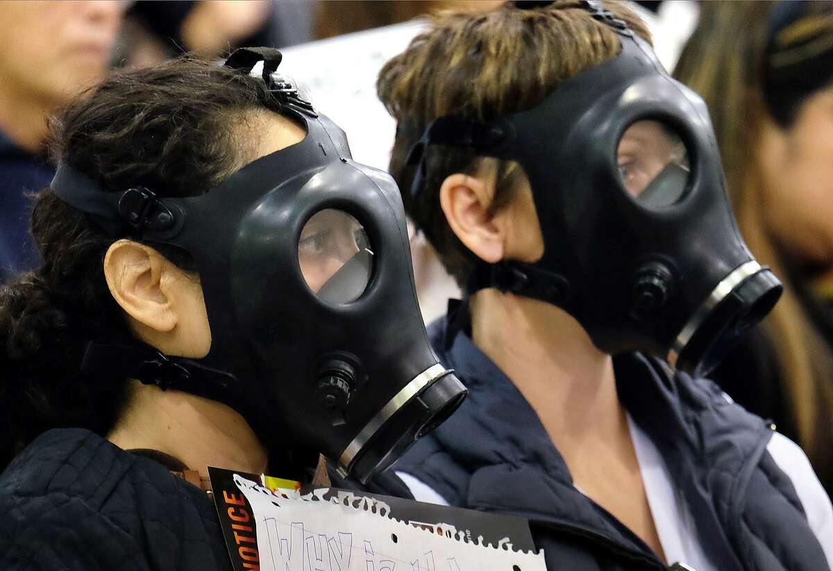 In this Jan. 16, 2016, file photo, protesters wearing gas masks attend a hearing over a gas leak at the southern California Gas Company's Aliso Canyon Storage Facility near the Porter Ranch section of Los Angeles.