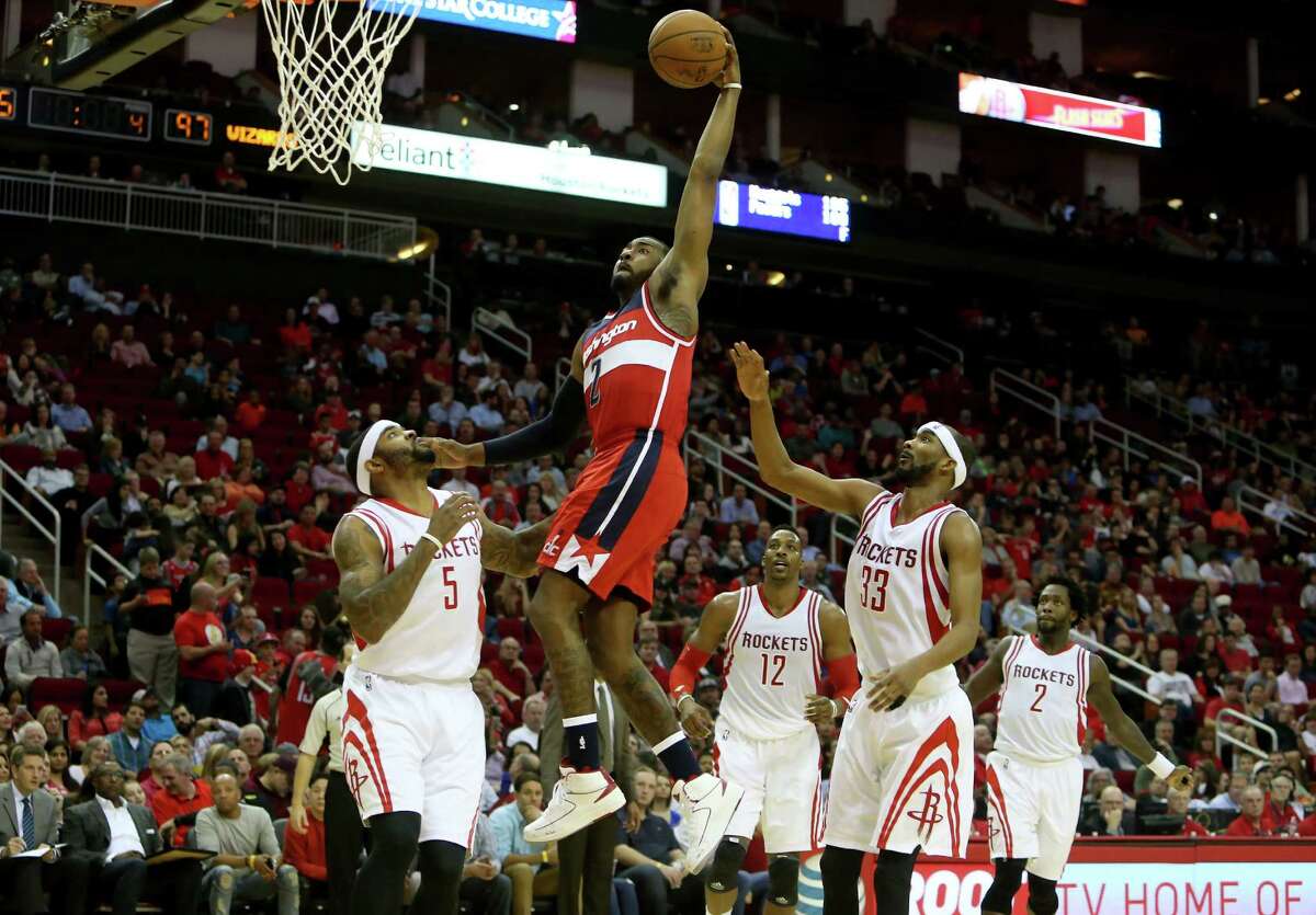 Wizards guard John Wall has no trouble scoring against three flat-footed Rockets on Saturday.