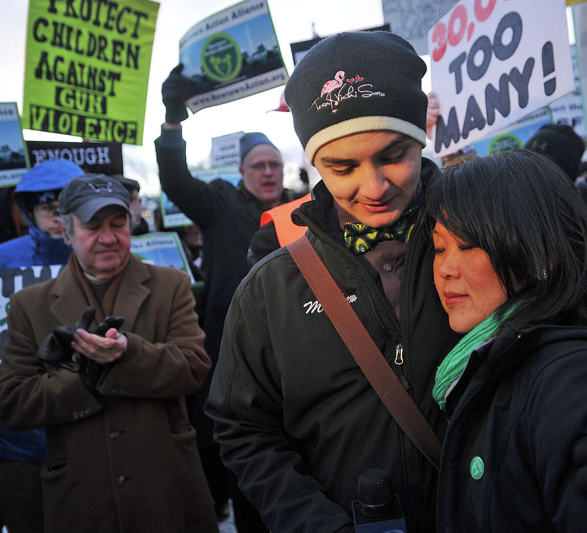 Matthew Soto, the brother of Sandy Hook massacre victim Victoria Soto, hugs Po Murray, chairwoman of Newtown Action Alliance, during a rally outside the National Shooting Sports Foundation's corporate headquarters in Newtown.