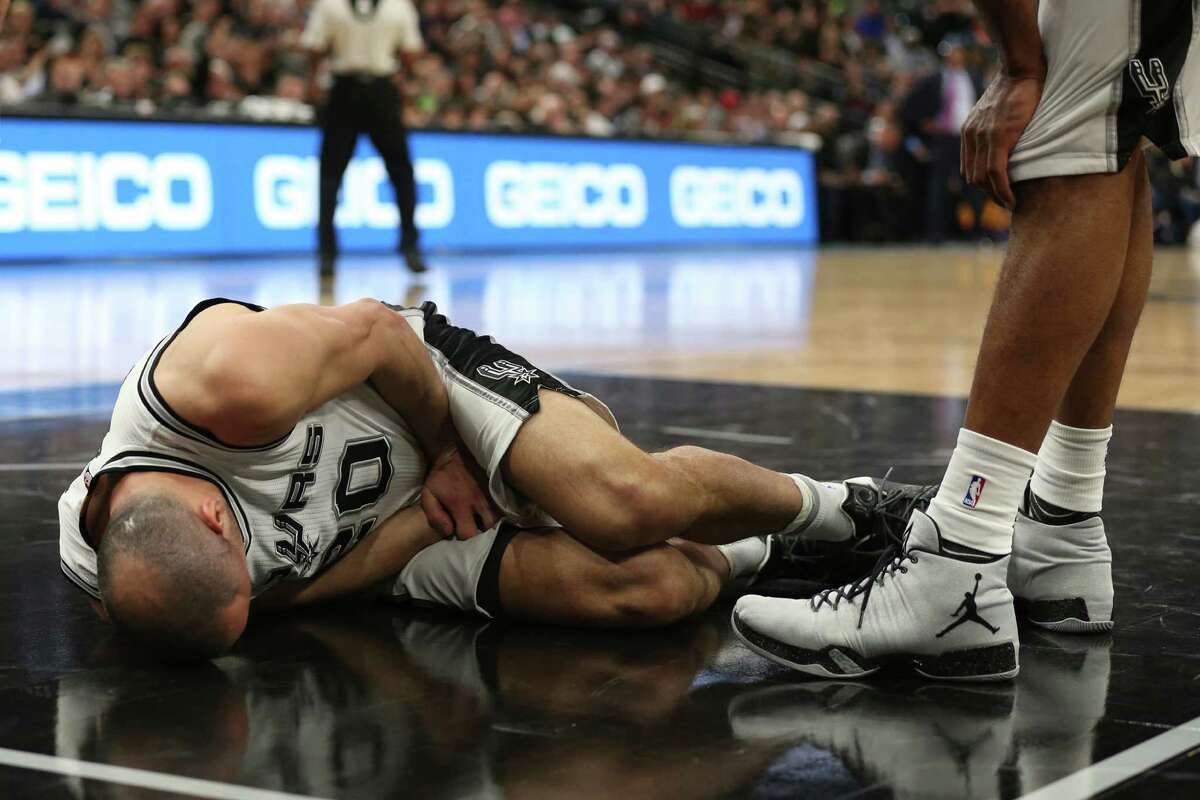 San Antonio Spurs' Manu Ginobili lies on the court after he was kneed by New Orleans Pelicans' Ryan Anderson during the second half at the AT&T Center, Wednesday, Feb. 3, 2016. Anderson was called for an offensive foul.