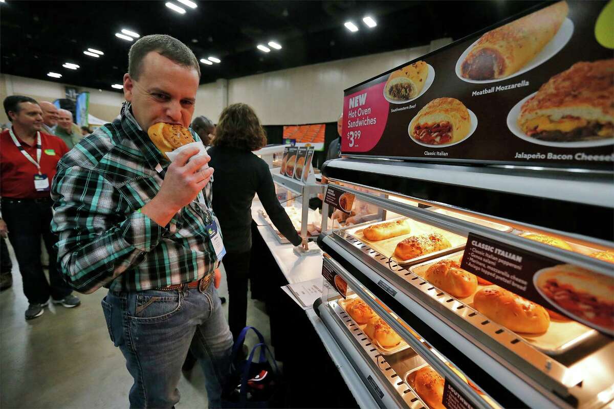 CST Brands store manager Jamie Henson takes a bite of a meatball mozzarella sandwich during the company's annual convention for its store managers at the Convention Center on Thursday. Managers from 1,200 company-owned stores get to visit with about 100 suppliers to see a cross section of new products offered to CST to enhance sales in their stores.