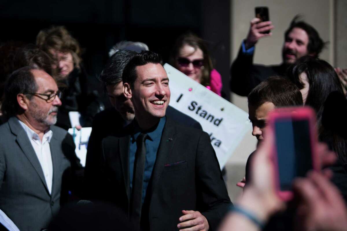 David Daleiden, center, of California, who has been charged with tampering with a governmental record, a second-degree felony with a possible sentence of up to 20 years in prison, is received by pro-life protestors on front of the Harris County Criminal Courthouse, Thursday, Feb. 4, 2016, in Houston.