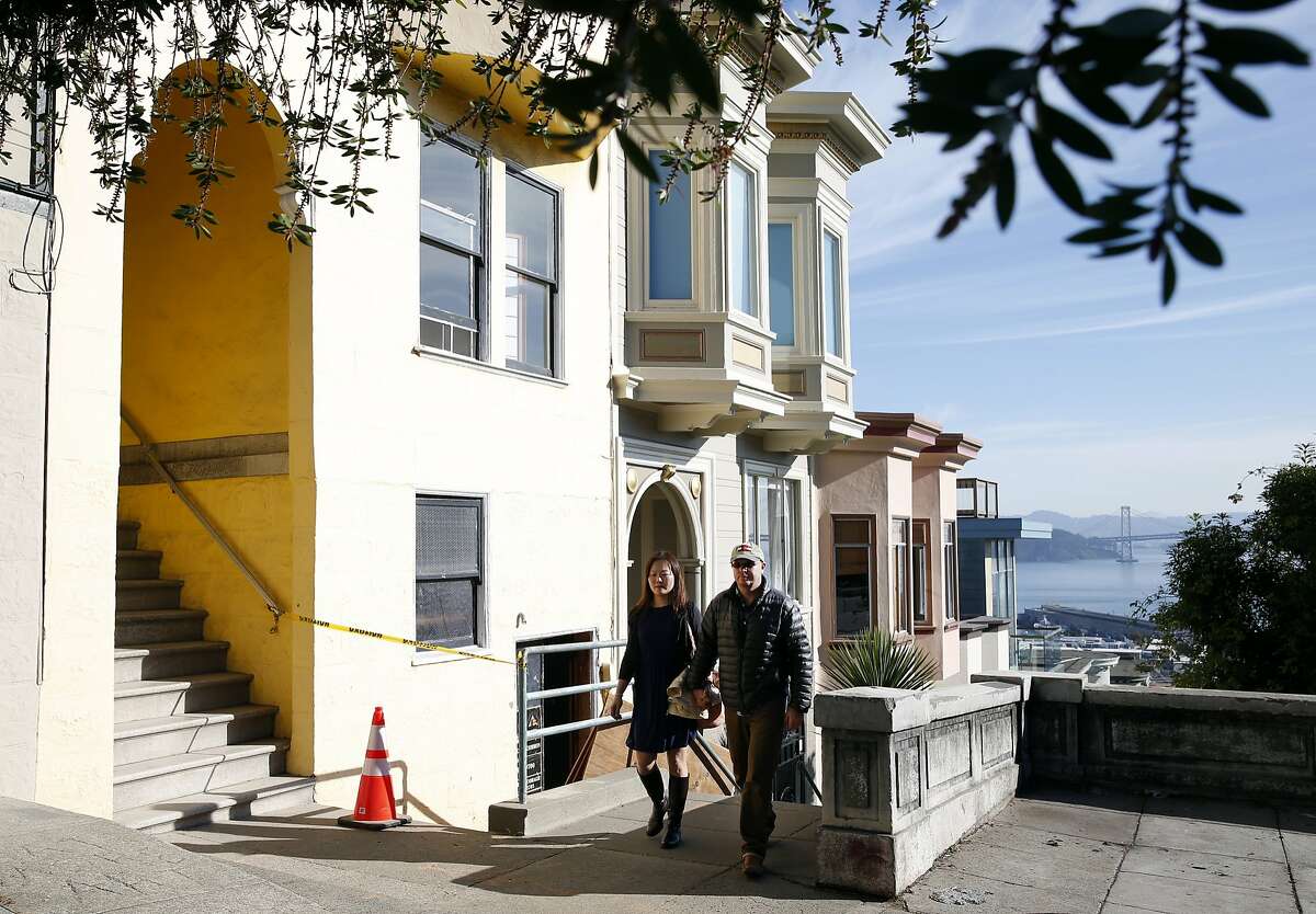 Michelle Huang and Tom Payne walk past the building on Vallejo Street where they own three TIC units in San Francisco, Calif. on Thursday, Feb. 4, 2016. They are embroiled in a feud with the owner of one of the other units who rented one of theirs through Airbnb and is now claiming residency asserting tenants rights.