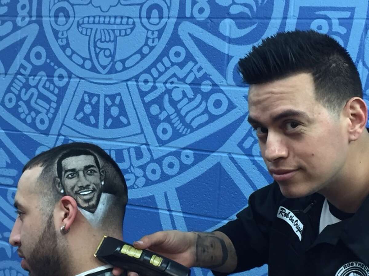 San Antonio barber Rob Ferrel works on engraving the likeness of the Spurs’ LaMarcus Aldridge into the head of customer Derek Miller. Ferrel owns Rob The Original’s Barber Shop.