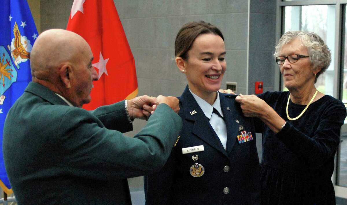 Christine Lennard (center) smiles as her parents Joe and Trudy Fernandez (left and right) pin colonel rank on her during her promotion ceremony at the New York State Division of Military Affairs in Latham, N.Y. on Dec. 22. Col. Lennard, of Guilderland, is a judge advocate general officer assigned to the National Guard Bureau's Special Victims Counsel Program. (U.S. National Guard photo by Master Sgt. Raymond Drumsta, 42nd Infantry Division/released)