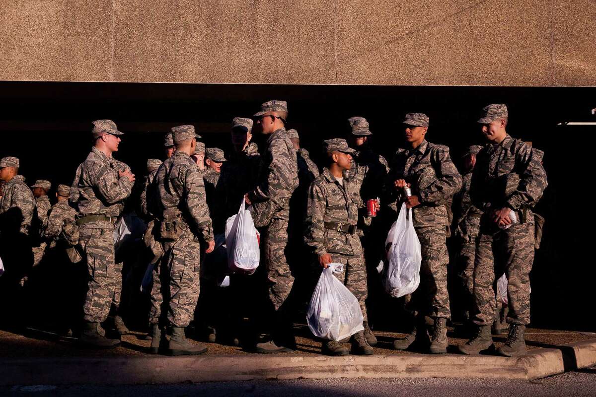 Trainees wait outside along with their purchases after the Lackland AFB at Joint Base San Antonio holiday shopping event for hundreds of recruits in December, shortly before VIA introduced a reduced-fare program for active military members.