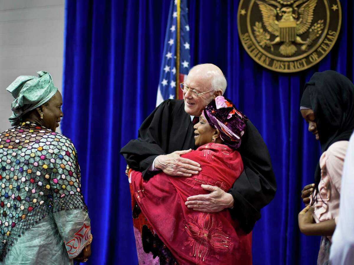U.S. District Judge Lynn N. Hughes embraces Djene Kaba Traore at a naturalization ceremony in 2014.