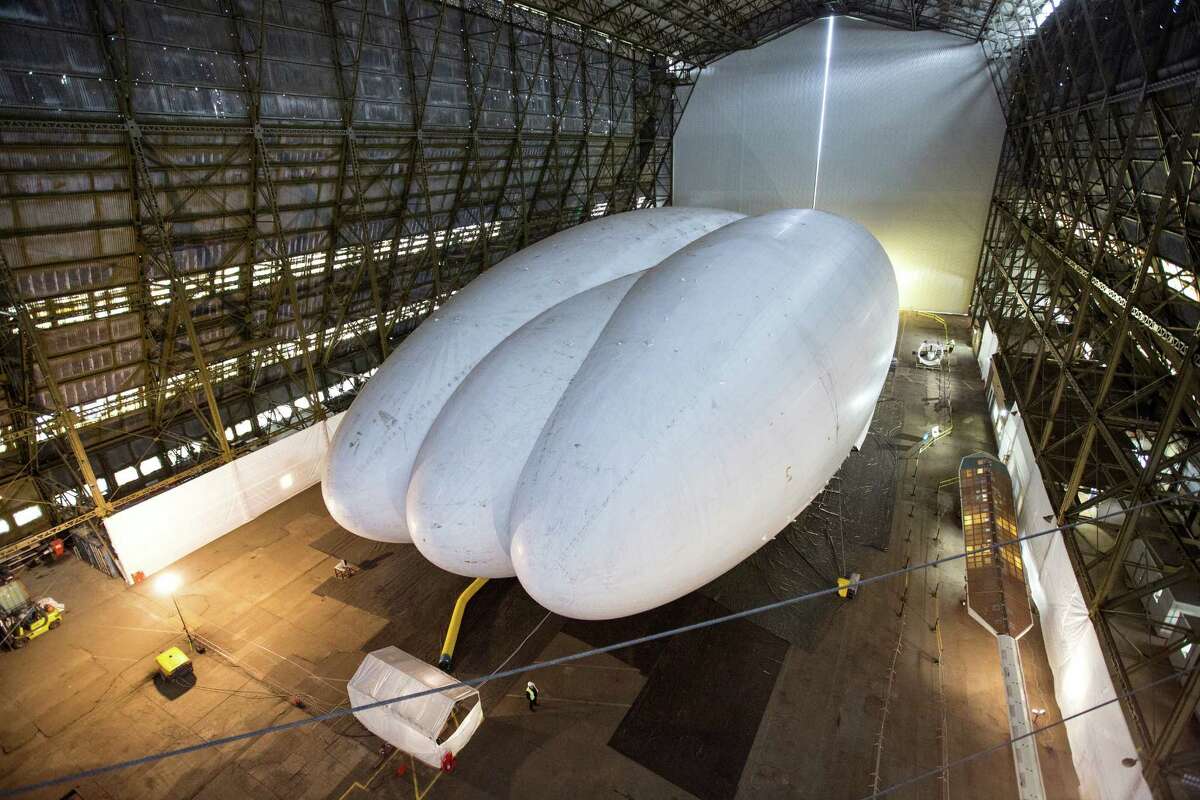 Mike Durham, the Technical Director at Hybrid Air Vehicles, admires the helium-filled 'Airlander' aircraft in a giant airship shed on February 28, 2014 in Cardington, England. The Airlander, which was originally developed for the US military before the project was cancelled due to budget cuts, is the world's longest aircraft at 92 meters. Although slow moving compared to conventional aircraft, the Airlander is able to carry large payloads over long distances very efficiently. Hybrid Air Vehicles' project to develop the technology further is being funded by a Government grant as well as private finance from individuals including Bruce Dickinson, the lead singer of the band Iron Maiden.