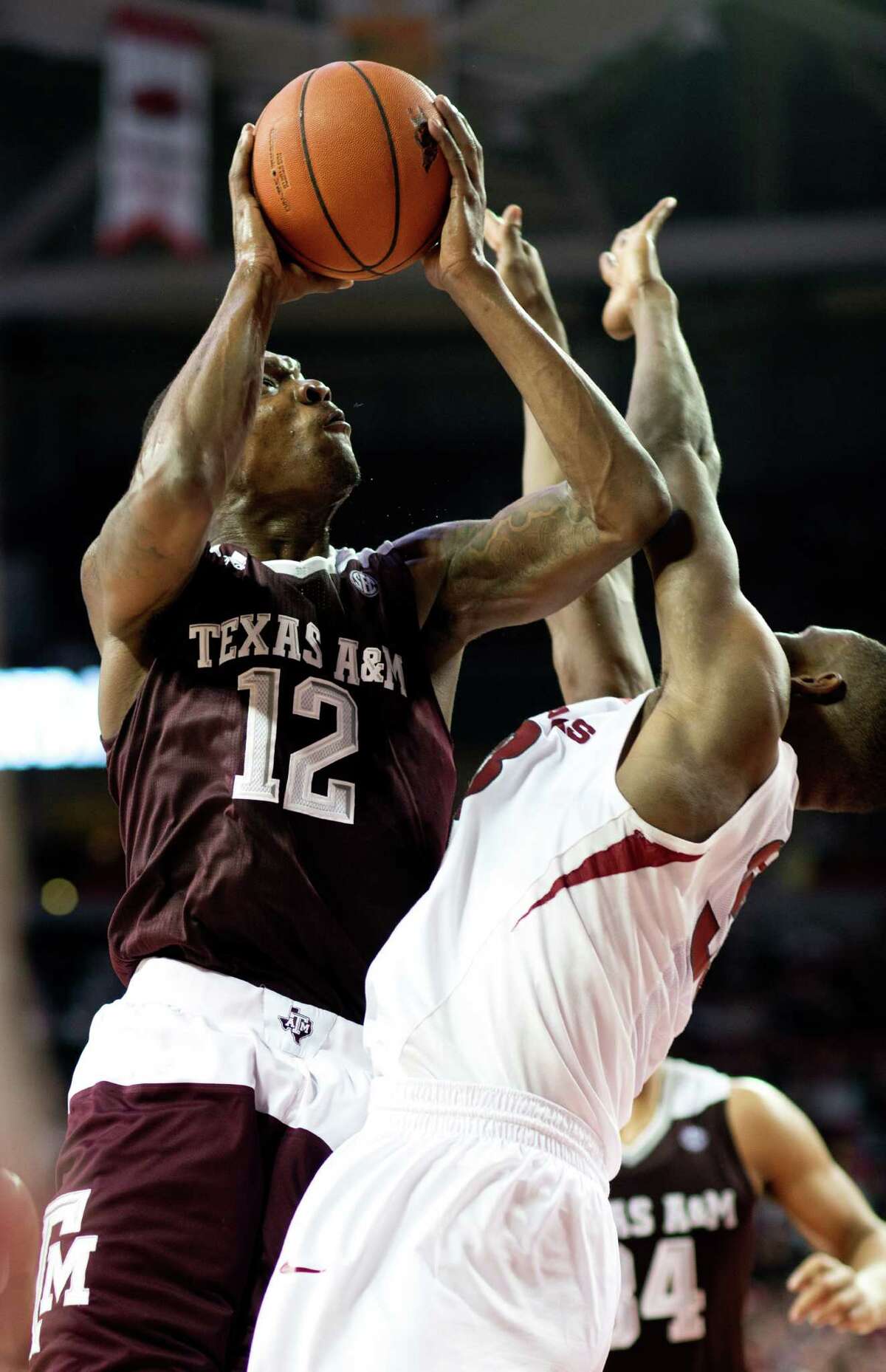 Texas A&M’s Jalen Jones is fouled by Arkansas’ Moses Kingsley (right) in the second half in Fayetteville, Ark., on Jan. 27, 2016.