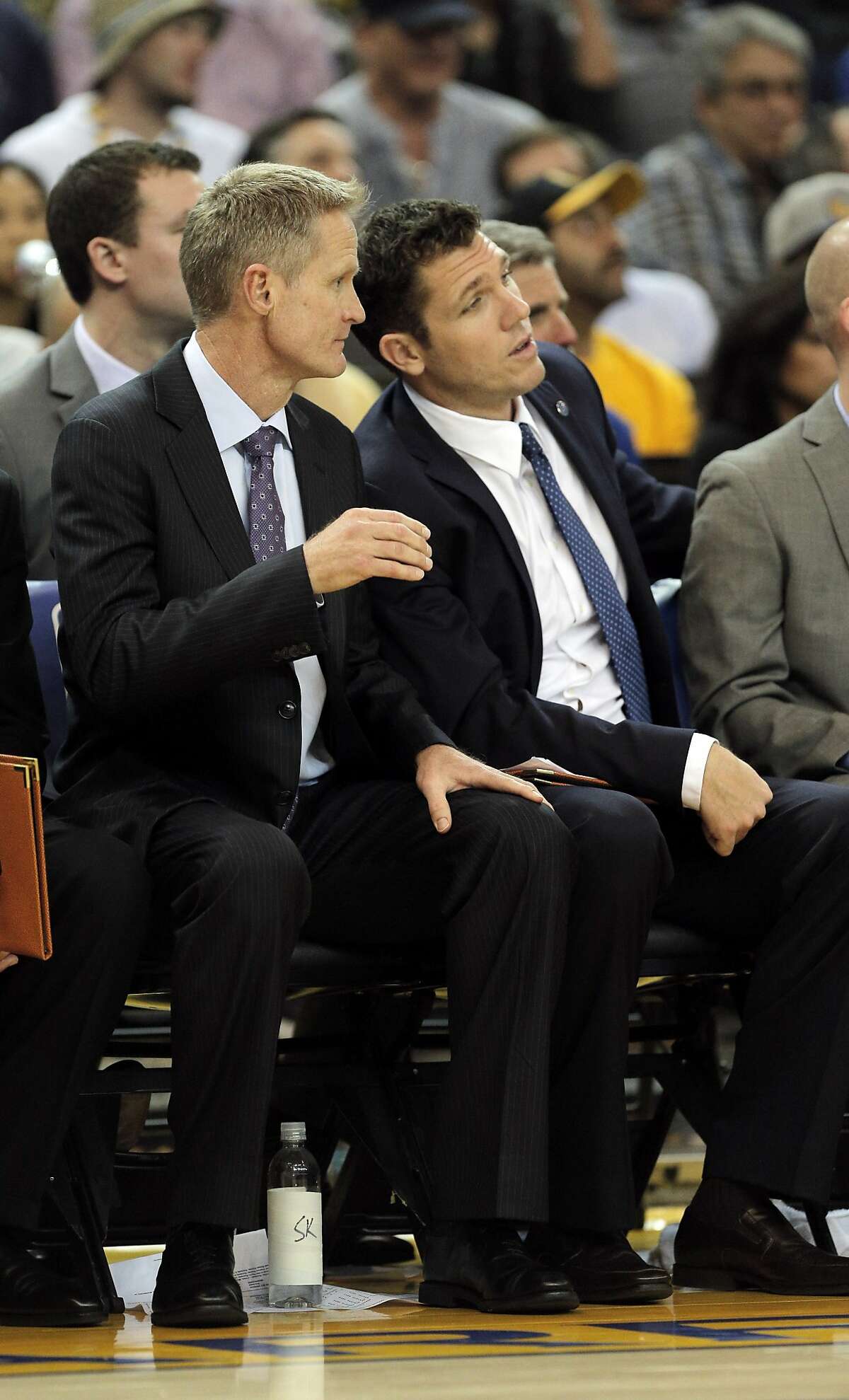 Head coach Steve Kerr, left, chats with assistant coach Luke Walton, right, during the first half of the game between the Golden State Warriors and the Houston Rockets at Oracle Arena in Oakland on February 9, 2016.