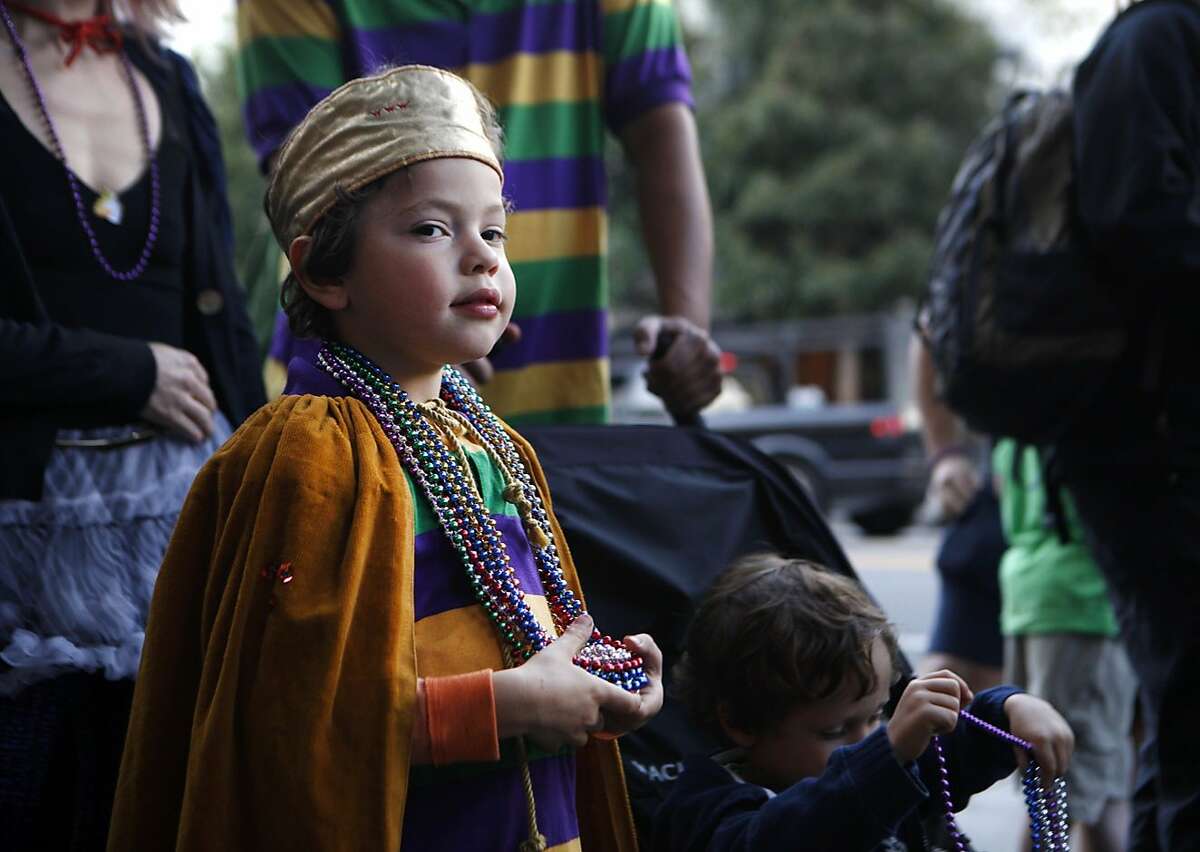 Parker Washington, 6, watches the musicians and dancers perform during the fifth annual Fat Tuesday parade through the Mission district in San Francisco, Calif., on Tuesday Feb. 9, 2016