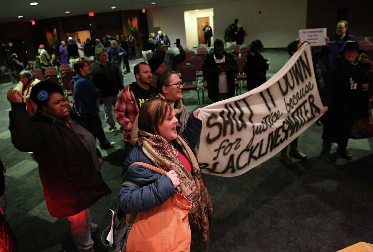 Protesters chant and yell after the Ferguson, Mo., city council meeting in Ferguson on Tuesday, Feb. 9, 2016, where the council voted to approve a modified consent decree with the United States Department of Justice. It is unclear if the Department of Justice will agree to the modifications. (David Carson/St. Louis Post-Dispatch via AP)