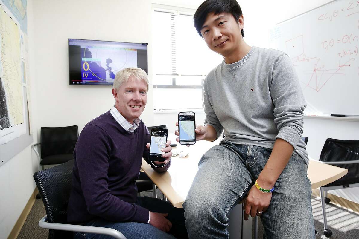 Professor Richard M. Allen, left, director of the UC Berkeley Seismological Laboratory, and his colleague Dr. Qingkai Kong, a leading Berkeley mathematician, hold up their phones running their MyShake app, in Allen's office the Seismology Department on the Cal campus in Berkeley, CA Wednesday, February 11, 2016. The pair have developed an earthquake detecting app for mobile phones that is set to launch on the Android platform.