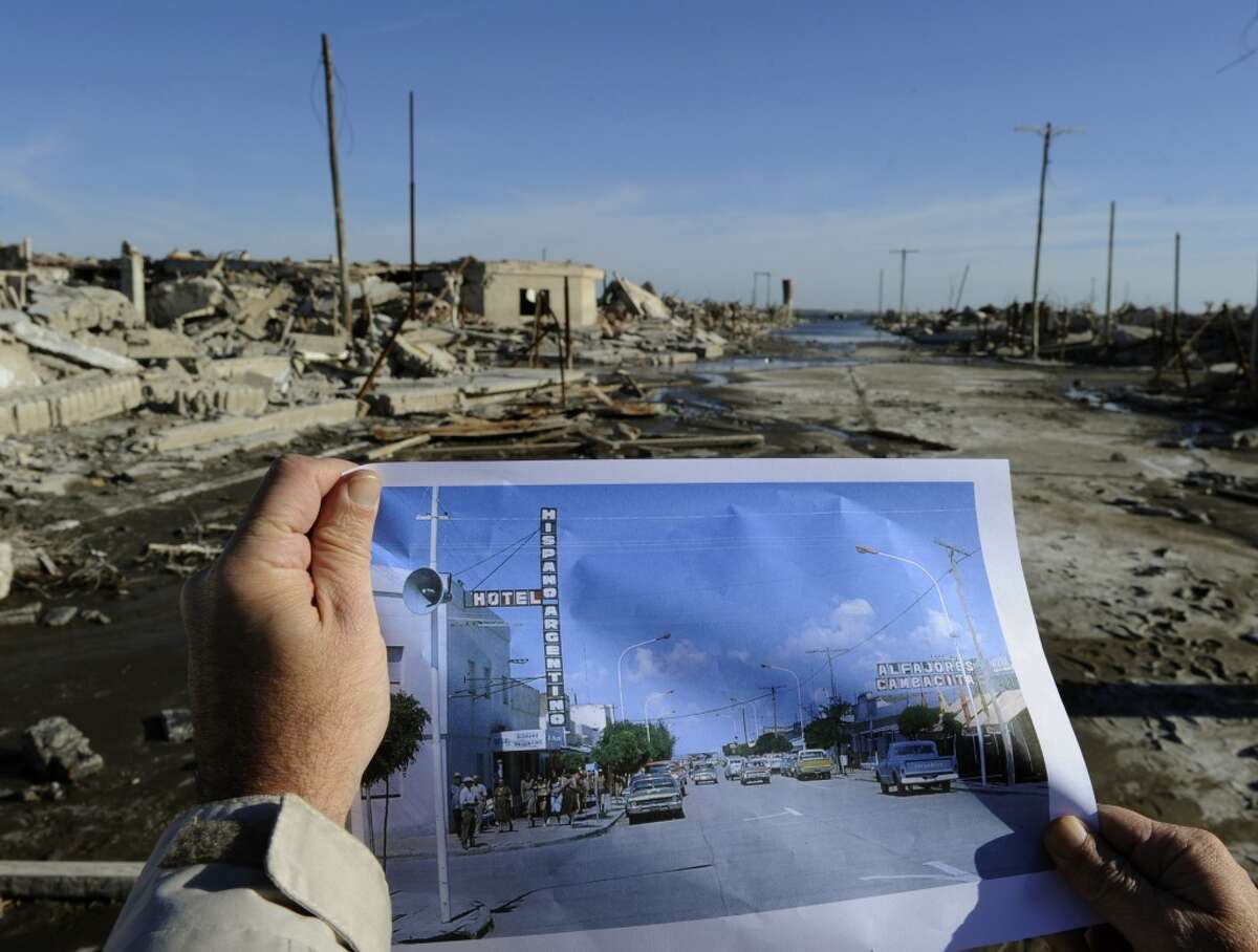 A man compares a picture of Lago Epecuen village taken in the 70's with the current state of the place -- flooded for almost 25 years by the salt water of Epecuen lagoon.