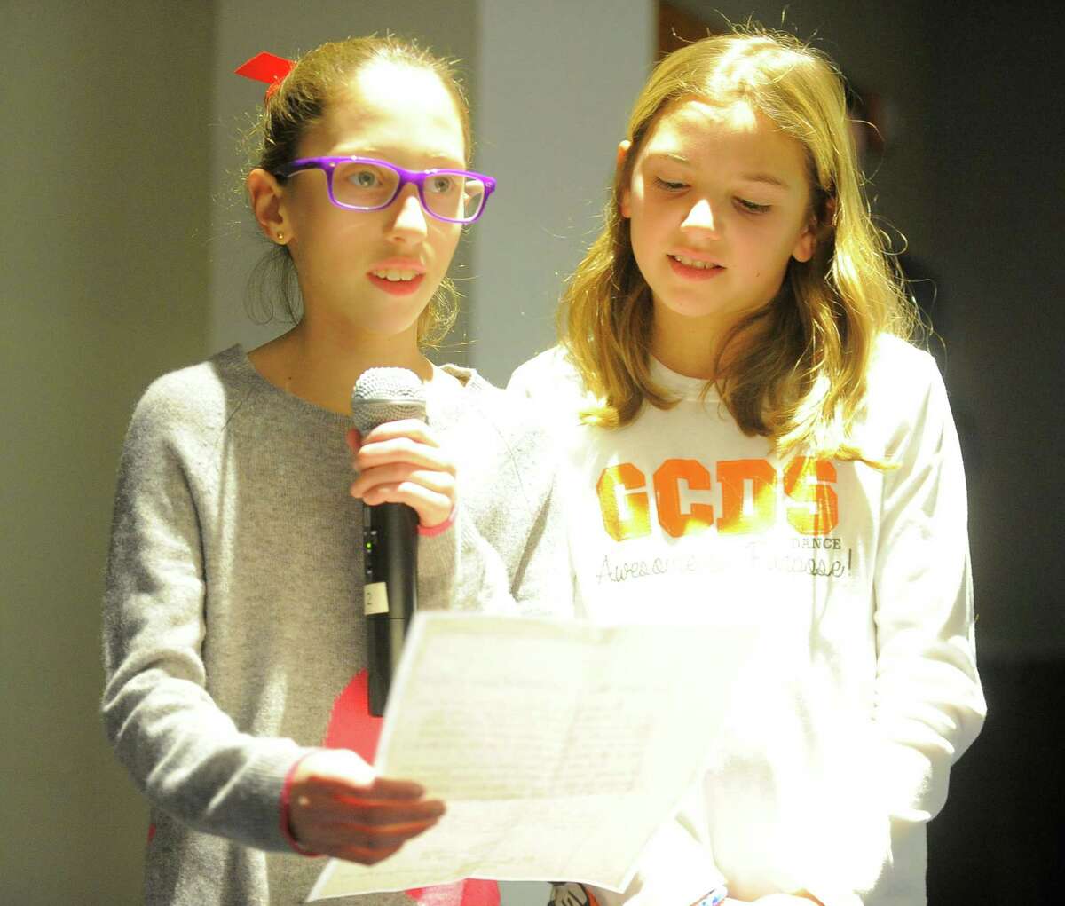 Annabelle Elkin, 10, of Old Greenwich, stands and listen as 11-year-old Sami Goldman, of Old Greenwich, reads a letter she wrote to Connecticut Gov. Dannel P. Malloy during a town hall forum in Stamford on Thursday.