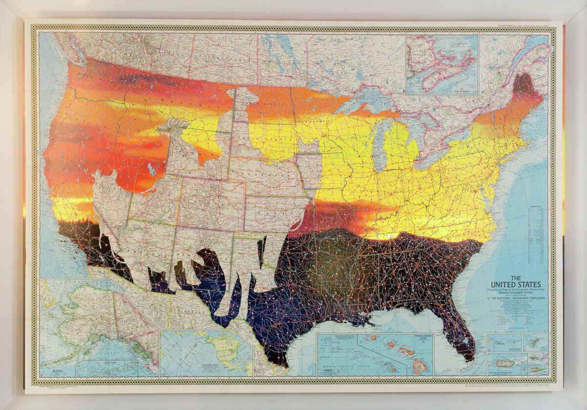 Time-lapse video of a Western sunset plays under an intricately map in one of the mixed-media works of Nick Vaughan and Jake Margolin's installation "50 States: Wyoming" at the Art League Houston.