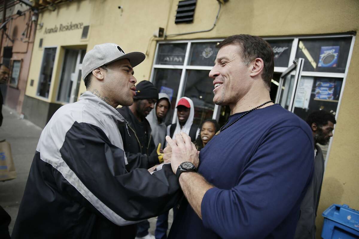 Tony Robbins (right), motivational speaker and author, is greeted by Mariano Fernandez (left) of San Francisco after Robbins was spotted by locals as he left Fraternite Notre Dame Mary of Nazareth Soup Kitchen after visiting with Sister Mary Valerie and Sister Mary Benedicte (both not shown) to discuss solutions to their eviction on Thursday, February 11, 2016 in San Francisco, Calif.