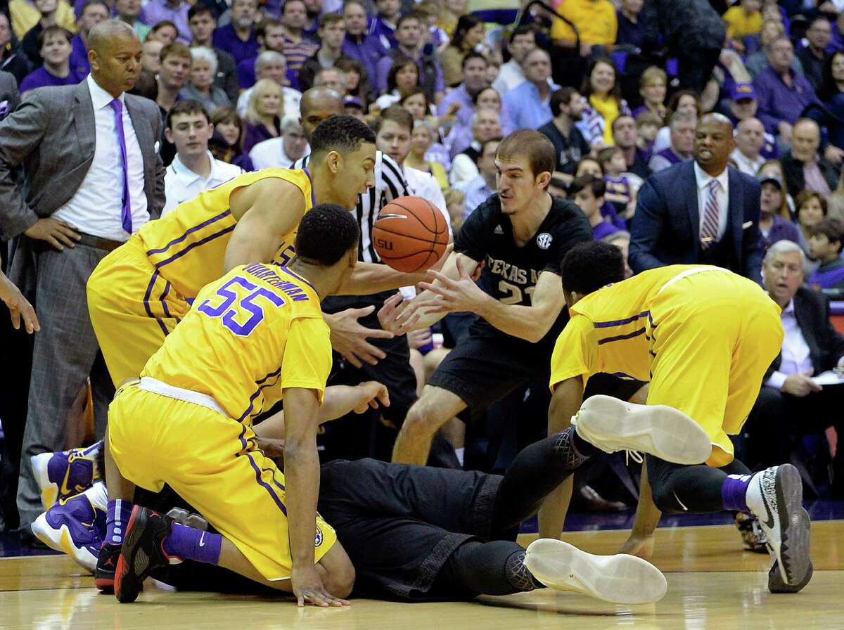 As LSU head coach Johnny Jones, standing left, watches, LSU guard Tim Quarterman (55), LSU forward Ben Simmons, second from left, Texas A&M guard Alex Caruso (21), Texas A&M center Tyler Davis (34), on floor, and LSU guard Antonio Blakeney (2) go after a loose ball in the first half of an NCAA college basketball game in Baton Rouge, La., Saturday, Feb. 13, 2016. (AP Photo/Bill Feig)