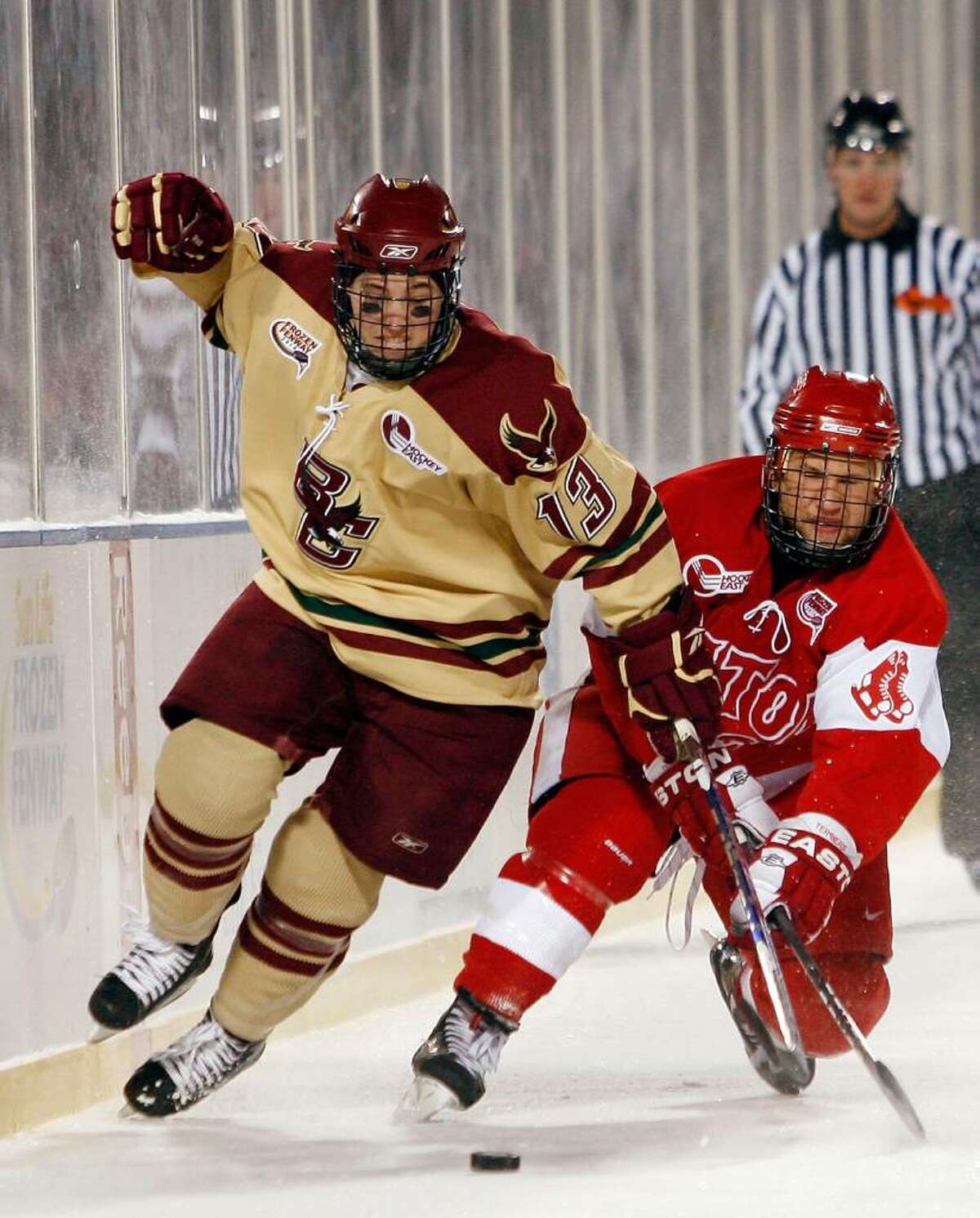 Boston College's Cam Atkinson (13) and Boston University's Luke Popko (26) ight for the puck on January 8 during the Sun Life Frozen Fenway Hockey Game at Fenway Park in Boston. Atkinson and the Eagles play MIami, Ohio in the Frozen Four Thursday.