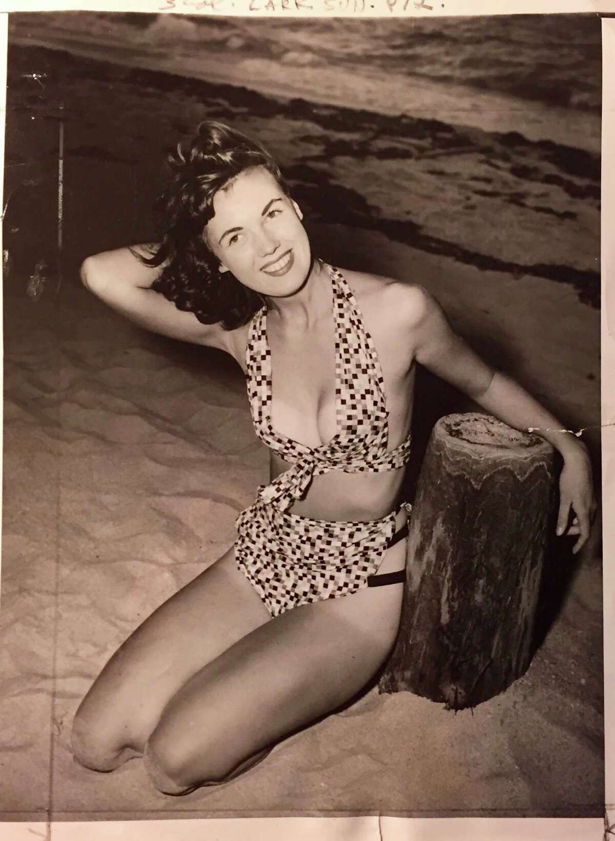 1949 info with photo: Bikini bathing suits are strictly second-rate stuff when you compare them with two of the latest creations of Bunny Yeager, who is shown doing her own modeling here.