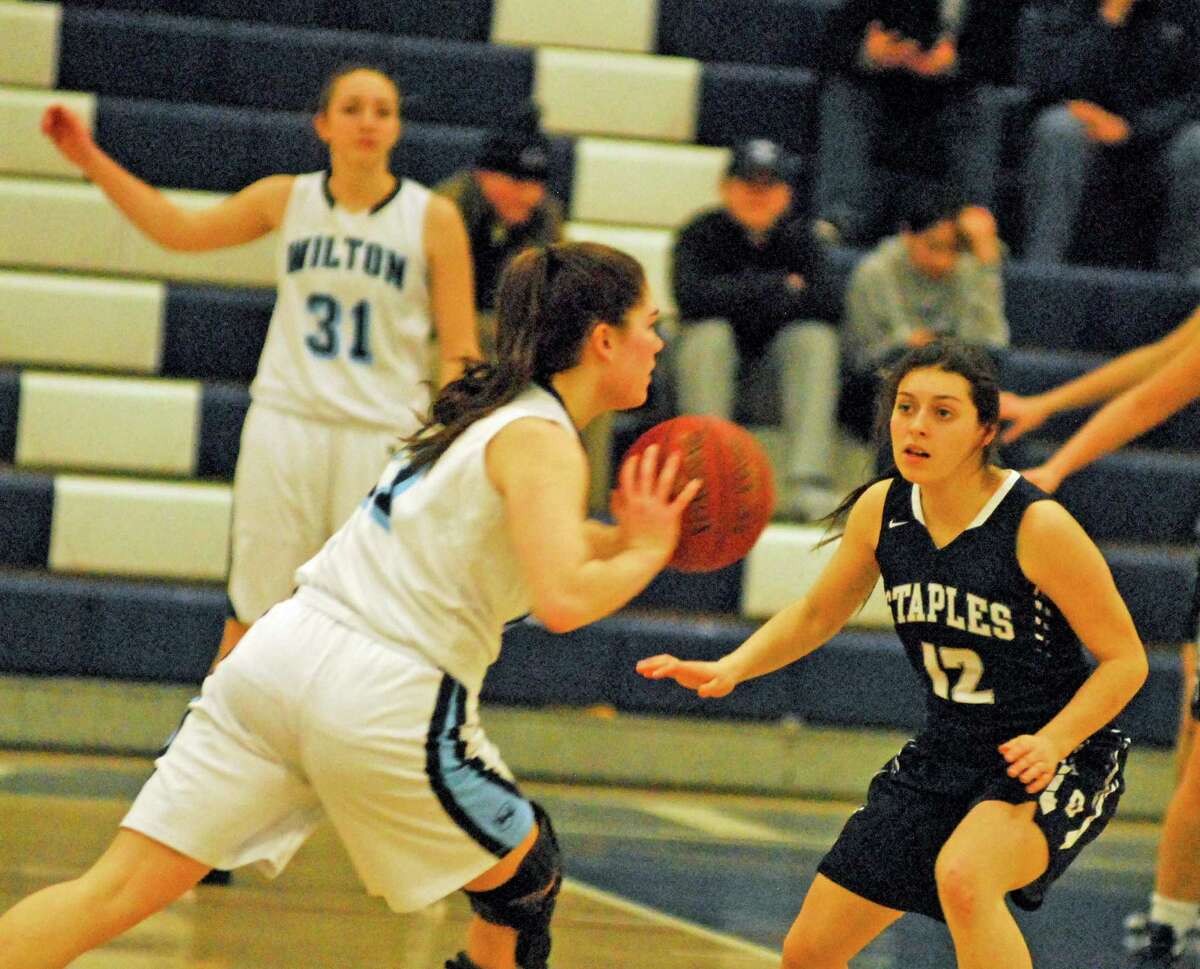 Staples' Gabby Perry, right, defends during a girls basketball game against Wilton on Monday, February 15th, 2016.