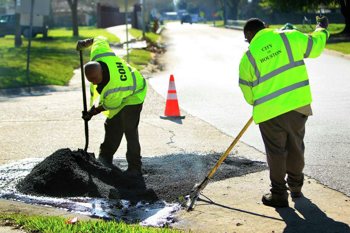 City workers repair a pothole last month. In January, crews filled 1,705 citizen-identified potholes.