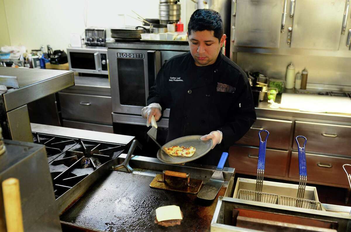 Head Chef Carlos Leal prepares a customer's meal at the newly-opended River Rock Tavern, a family-owned business in Derby, Conn. on Thursday Jan. 7, 2016.