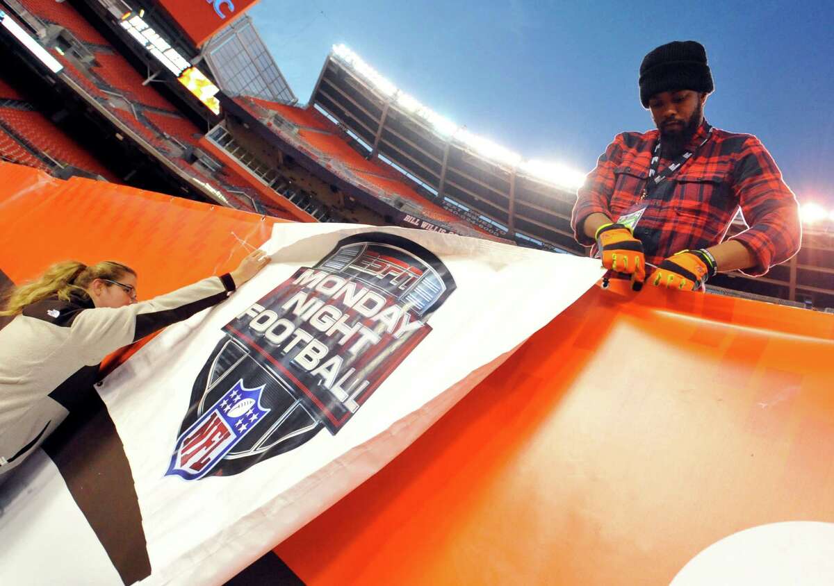 Workers install an ESPN Monday Night Football banner before an NFL football game between the Cleveland Browns and the Baltimore Ravens in November.