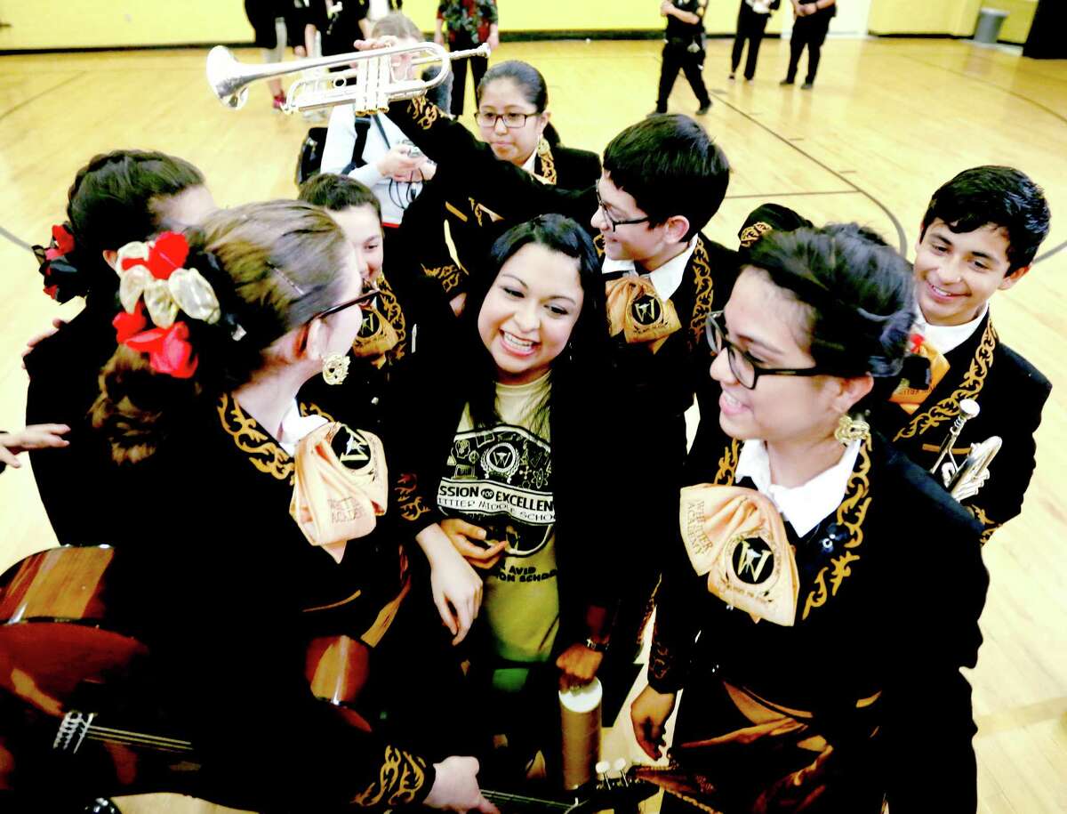 Whittier Middle School math teacher Laura Servin, center, receives a hug from the school's mariachi group Thursday morning Feb. 18, 2016 after she received the Milken Education Award. The only teacher in Texas to receive the award this year, Servin receives a $25,000 award she is allowed to spend as she wants, according to the Milken Family Foundation which administers the prize.
