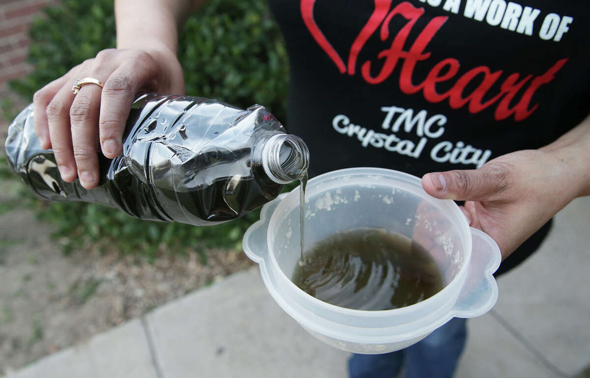 Mary Jane Surita pours from the bottle of discolored water she drew from her bathroom faucet as Crystal City residents deal with dark, polluted tap water on February 17, 2016.