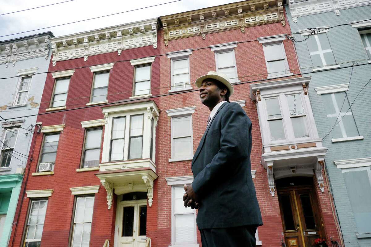 Mark Robinson stands on Lexington Avenue on Thursday, July 25, 2013 in Albany, NY, in front of two apartment buildings he has rehabbed and now being rented out. (Paul Buckowski / Times Union)