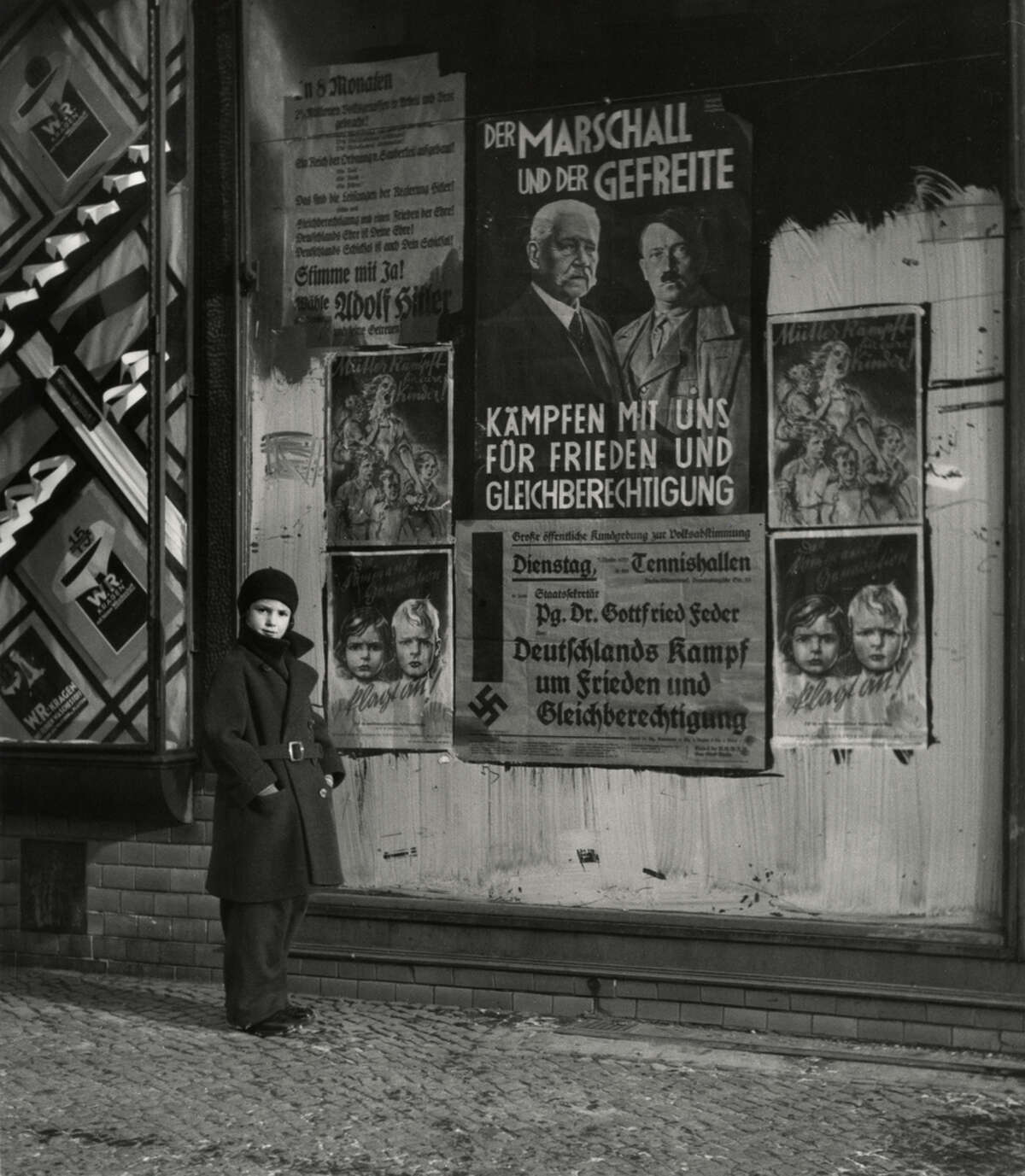Vishniac photographed his daughter, Mara, in front of an election poster for Hindenburg and Hitler, Berlin, 1933.