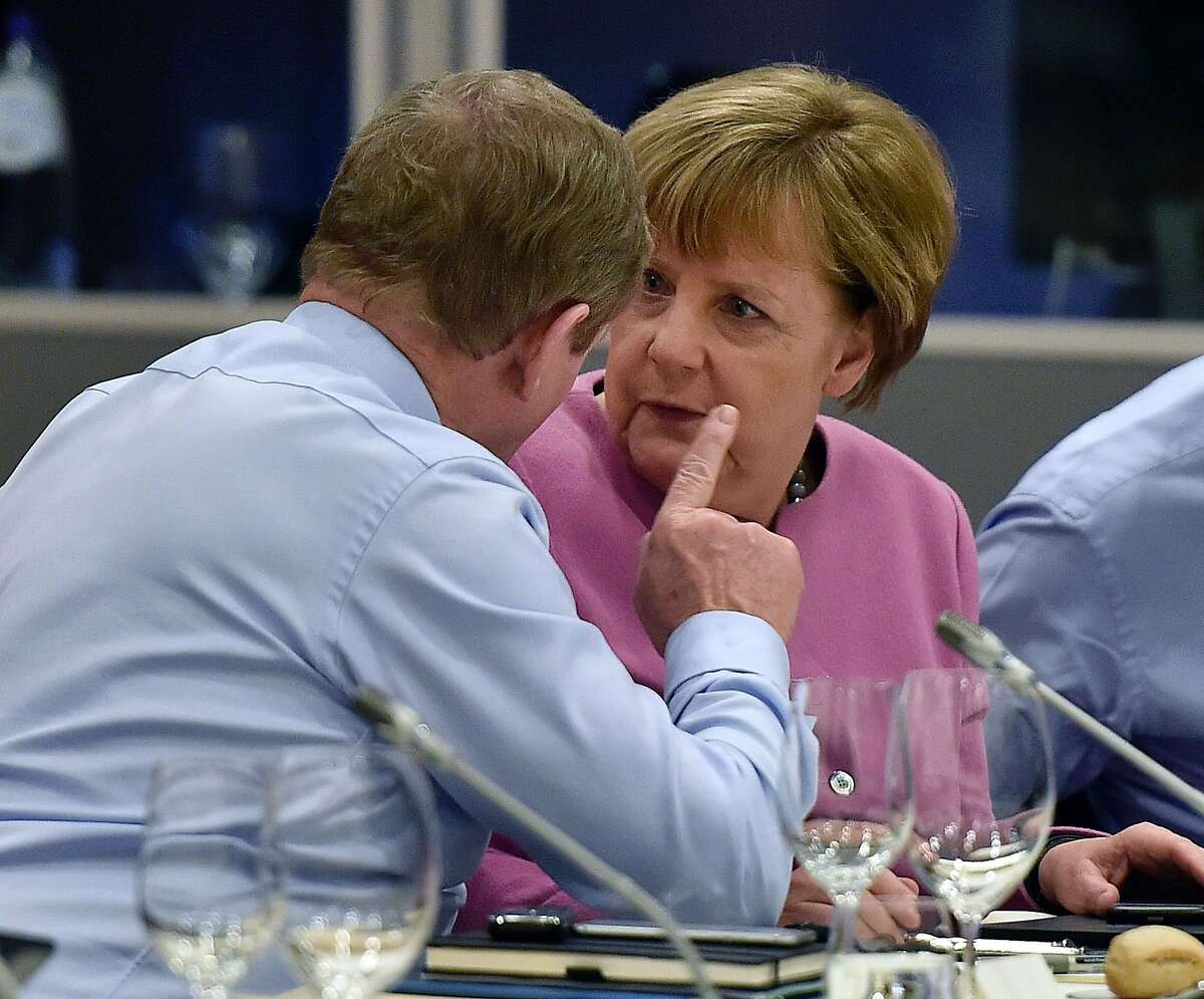 Irish Prime Minsiter Enda Kenny (L) speaks with , German Chancellor Angela Merkel (R) as they attend a European Union (EU) heads of state dinner during an EU summit in Brussels on February 19, 2016. EU leaders on February 19 agreed on a deal on British Prime Minister David Cameron's controversial reform demands to keep his country in the EU, Lithuania's president said. The agreement comes after two days and nights of haggling with European leaders at a Brussels summit. / AFP / POOL AND AFP / Martin MeissnerMARTIN MEISSNER/AFP/Getty Images