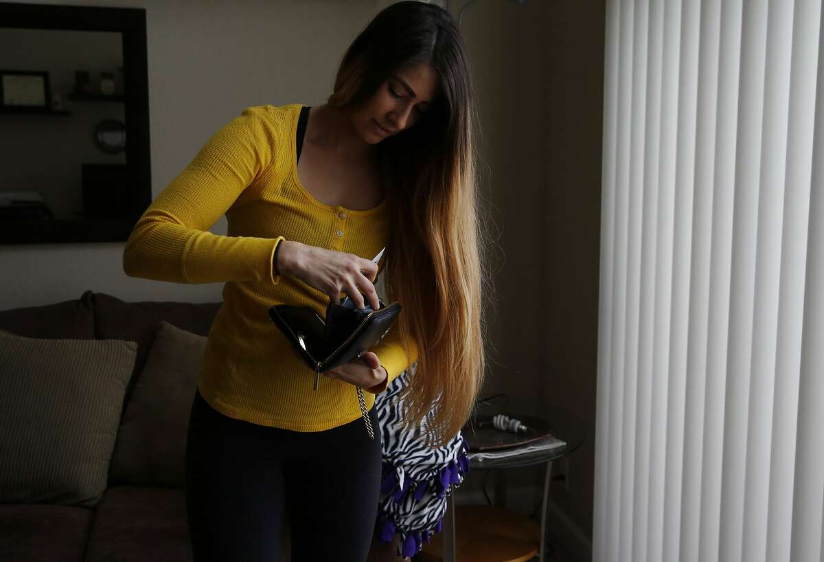 Ilyssa Russ puts her birth control away in her wallet after getting it out for a portrait in her home Feb. 19, 2016 in Santa Clara, Calif. Russ used Nurx to refill her birth control prescription online after which it was delivered to her door.