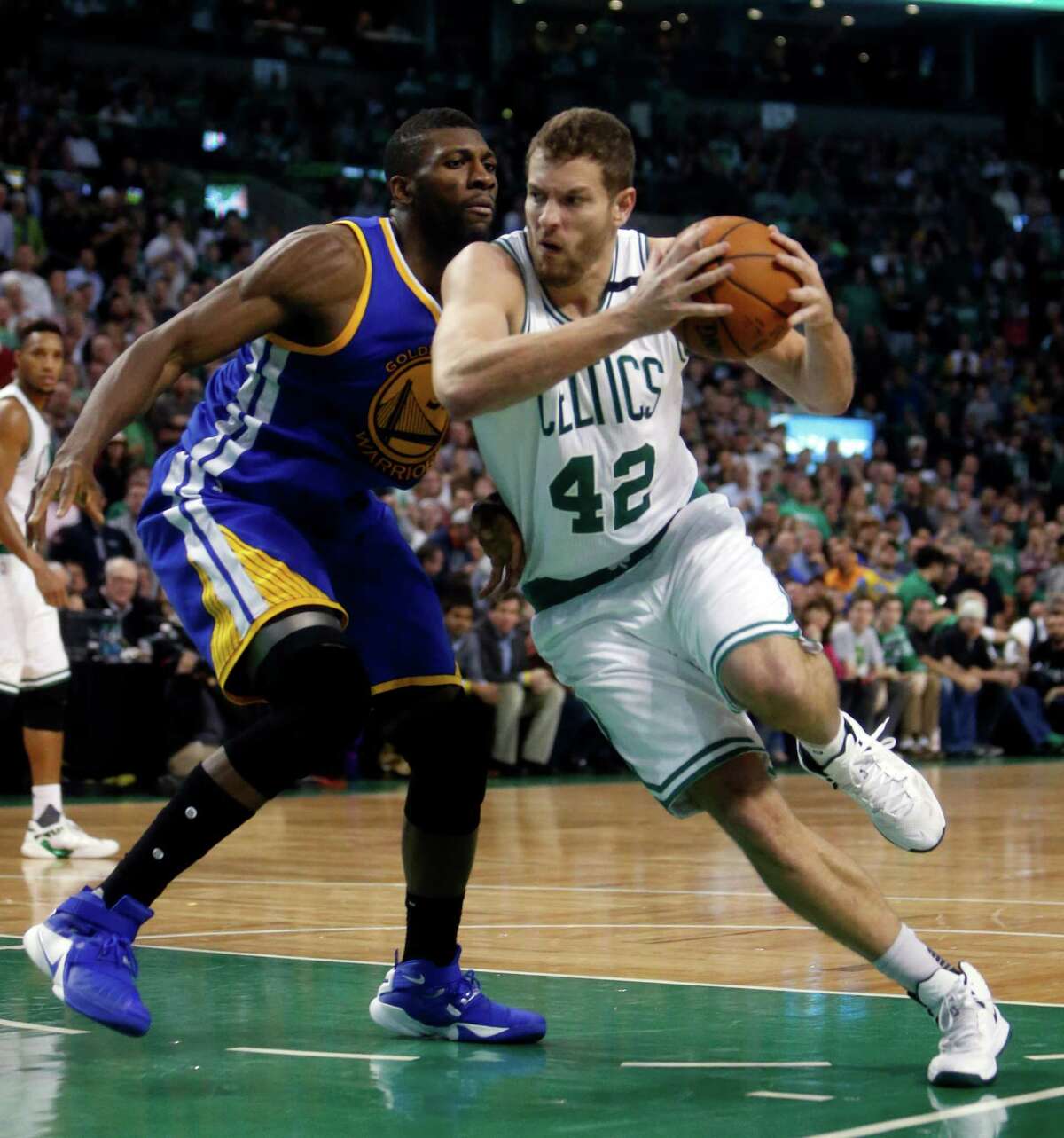 Boston Celtics' David Lee drives against Golden State Warriors' Festus Ezeli in 4th quarter during Warriors 124-119 double overtime win in NBA game at TD Garden in Boston, Massachusetts on Friday, December 11, 2015.